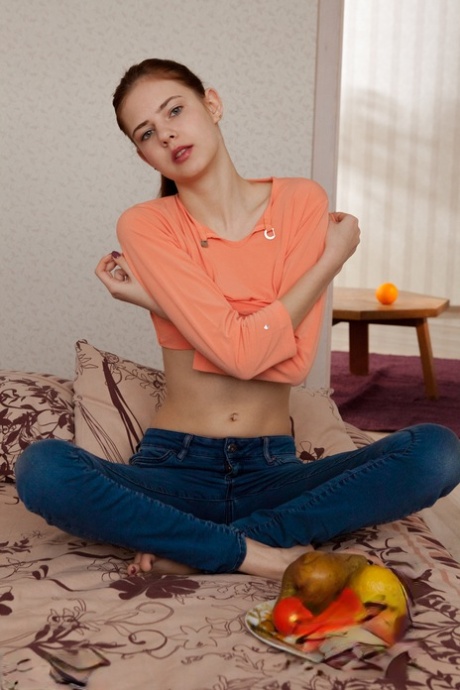 Leggy teen girl removes blue jeans and panties in order to model in the nude