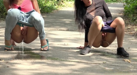 Miky Love and Amanda Estela pee at the same time on a path through the woods