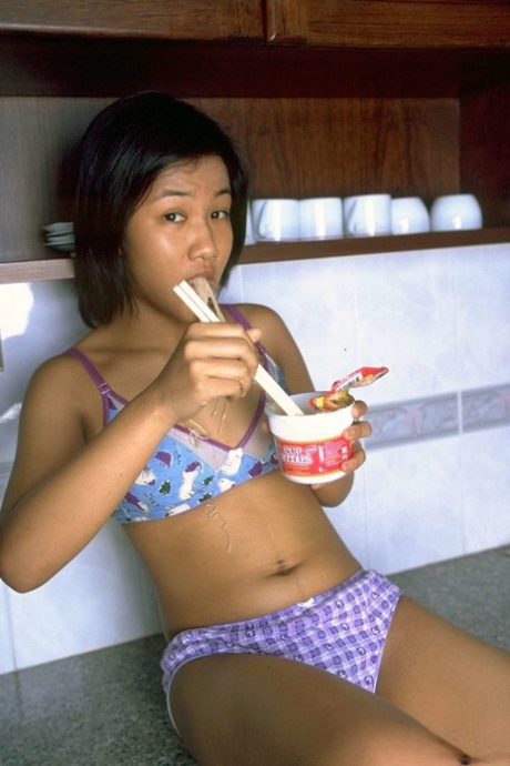 Cute Asian girl shows the pink of her pussy after eating noodles