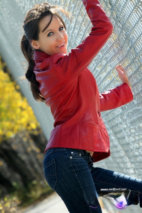 Teen amateur Andi Land shows her small tits & pussy against a chain-link fence