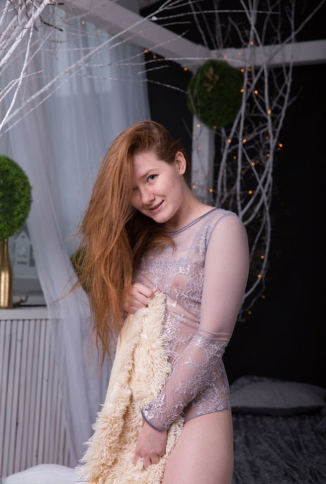 Natural redhead Anika B removes a bodysuit before showcasing her trimmed pussy