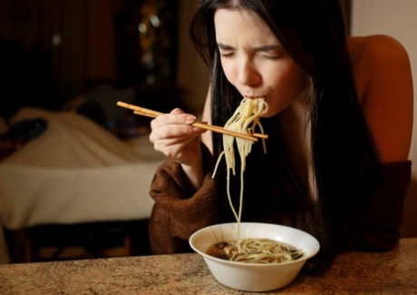 Brunette teen Chanel Fenn gets totally naked while eating a bowl of noodles