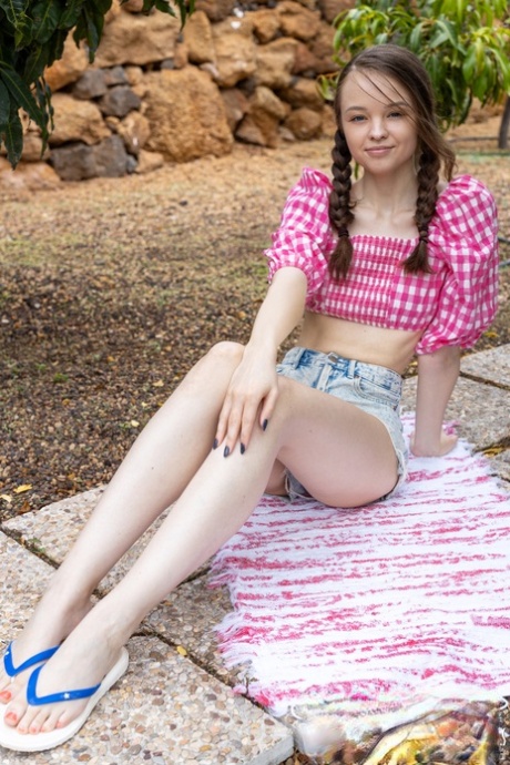 Adorable young girl Shea gets totally naked on a patio stone walkway