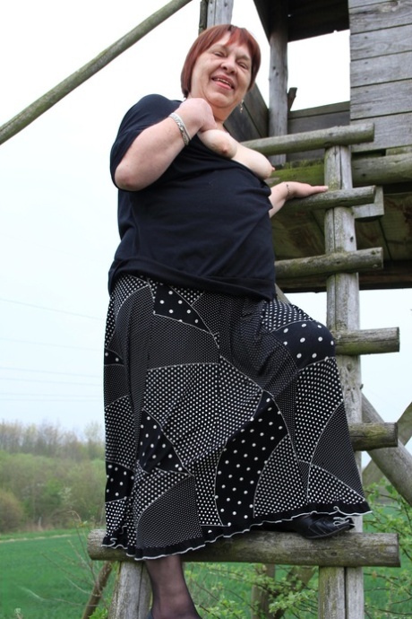 Redhead granny Sheila reveals her swollen vagina on an outdoor ladder