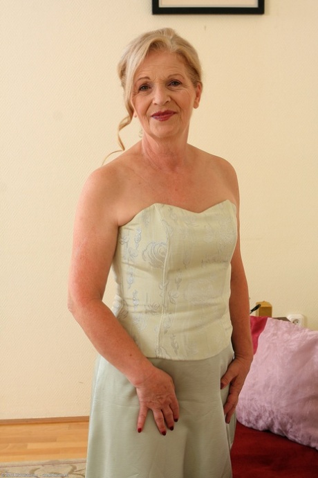 Kinky granny Nelli loses her dress and flaunts her pussy on a couch
