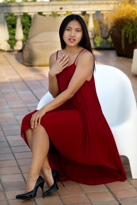 Glamour babe in a long maroon dress May Thai strips to show her delicious slit