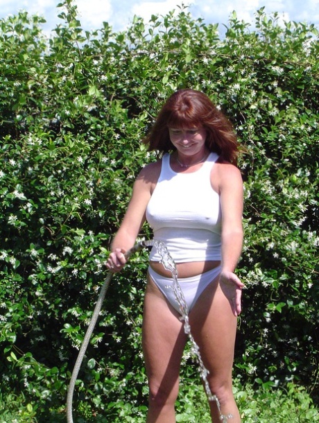 Slutty big boobed wife Dee gets wet while watering plants in the garden
