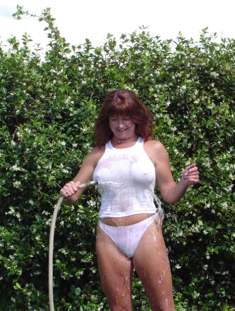 Slutty big boobed wife Dee gets wet while watering plants in the garden