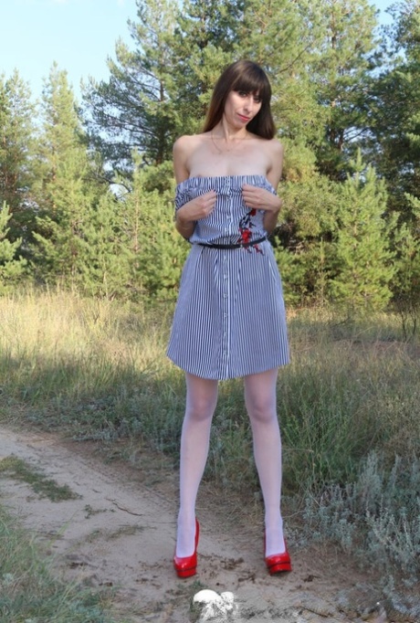 Naughty MILF strips down to her stockings & toys with a dildo outdoors